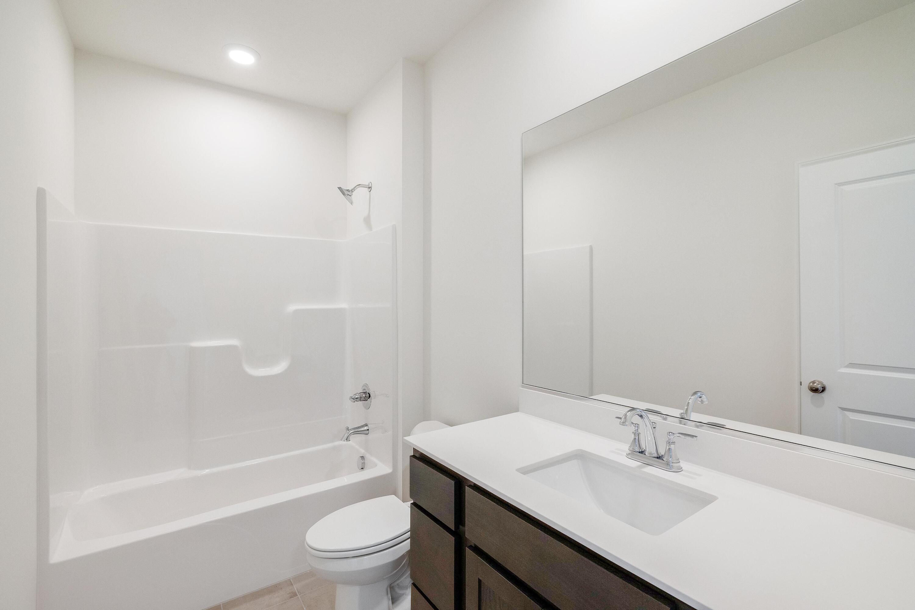 6821 Tucson Road Schererville, IN 46375 - Photo 17 of 24 a bathroom with a bathtub shower sink vanity and toilet