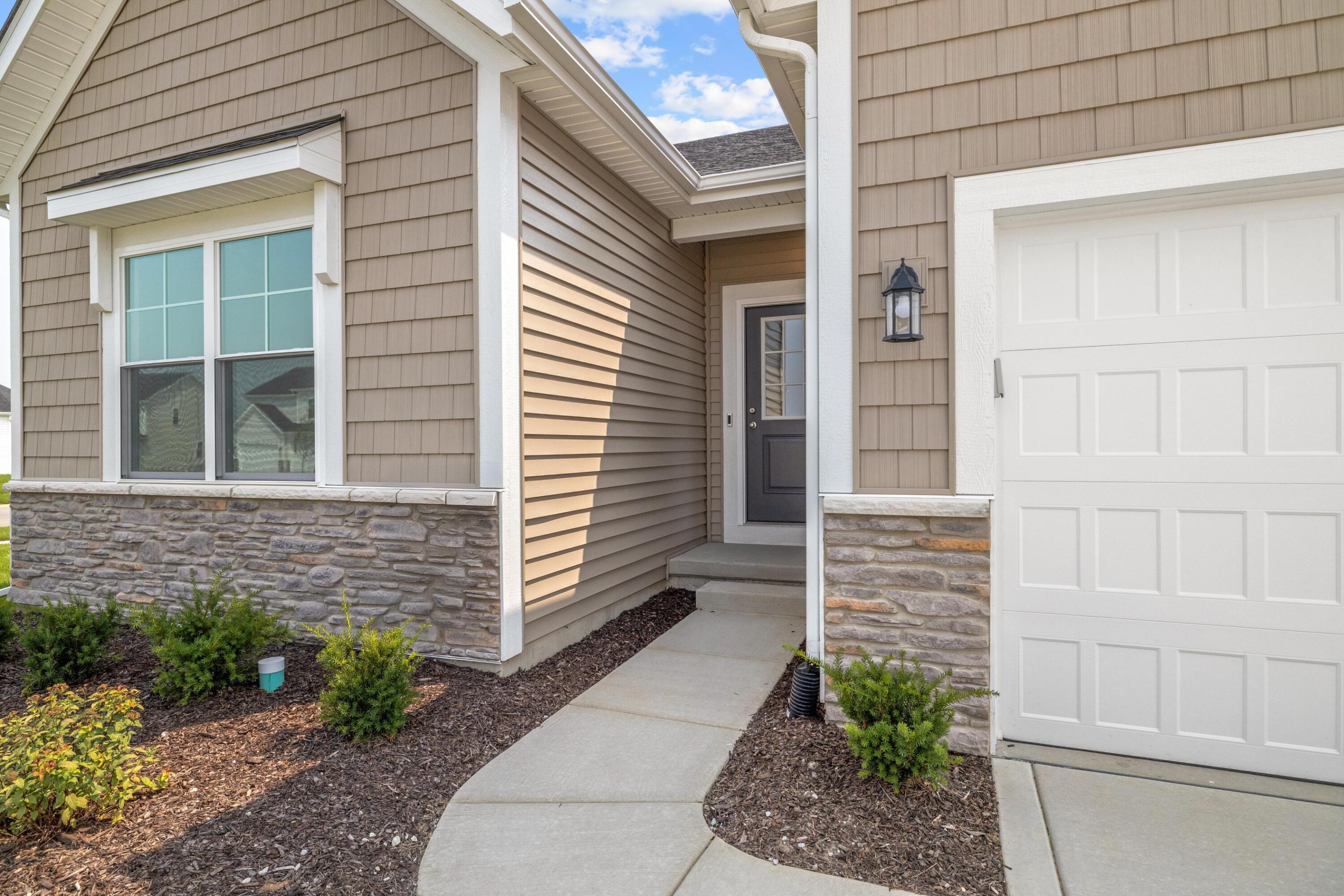 6821 Tucson Road Schererville, IN 46375 - Photo 3 of 24 a front view of a house with a garden