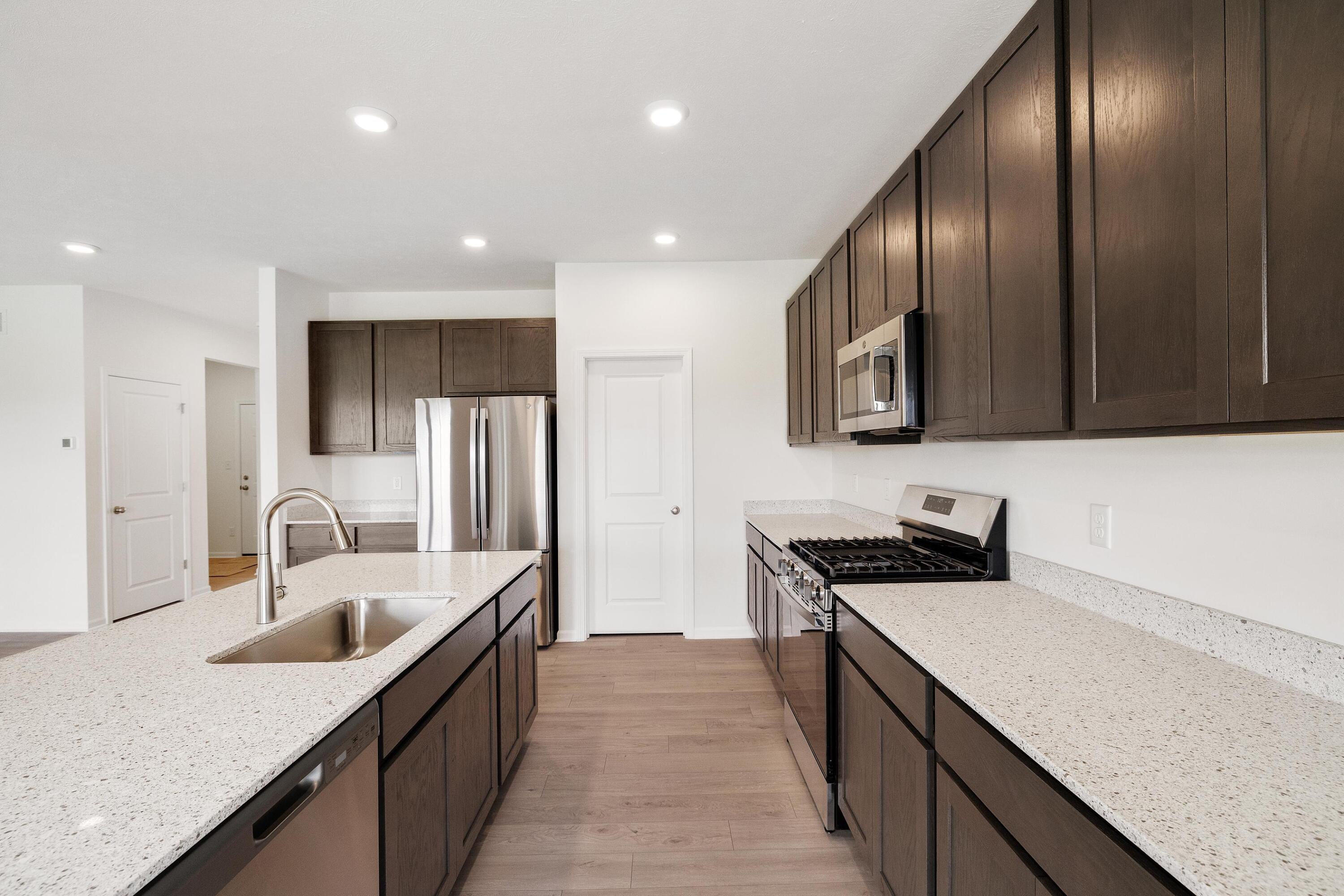 6821 Tucson Road Schererville, IN 46375 - Photo 6 of 24 a kitchen with stainless steel appliances granite countertop sink stove refrigerator and cabinets