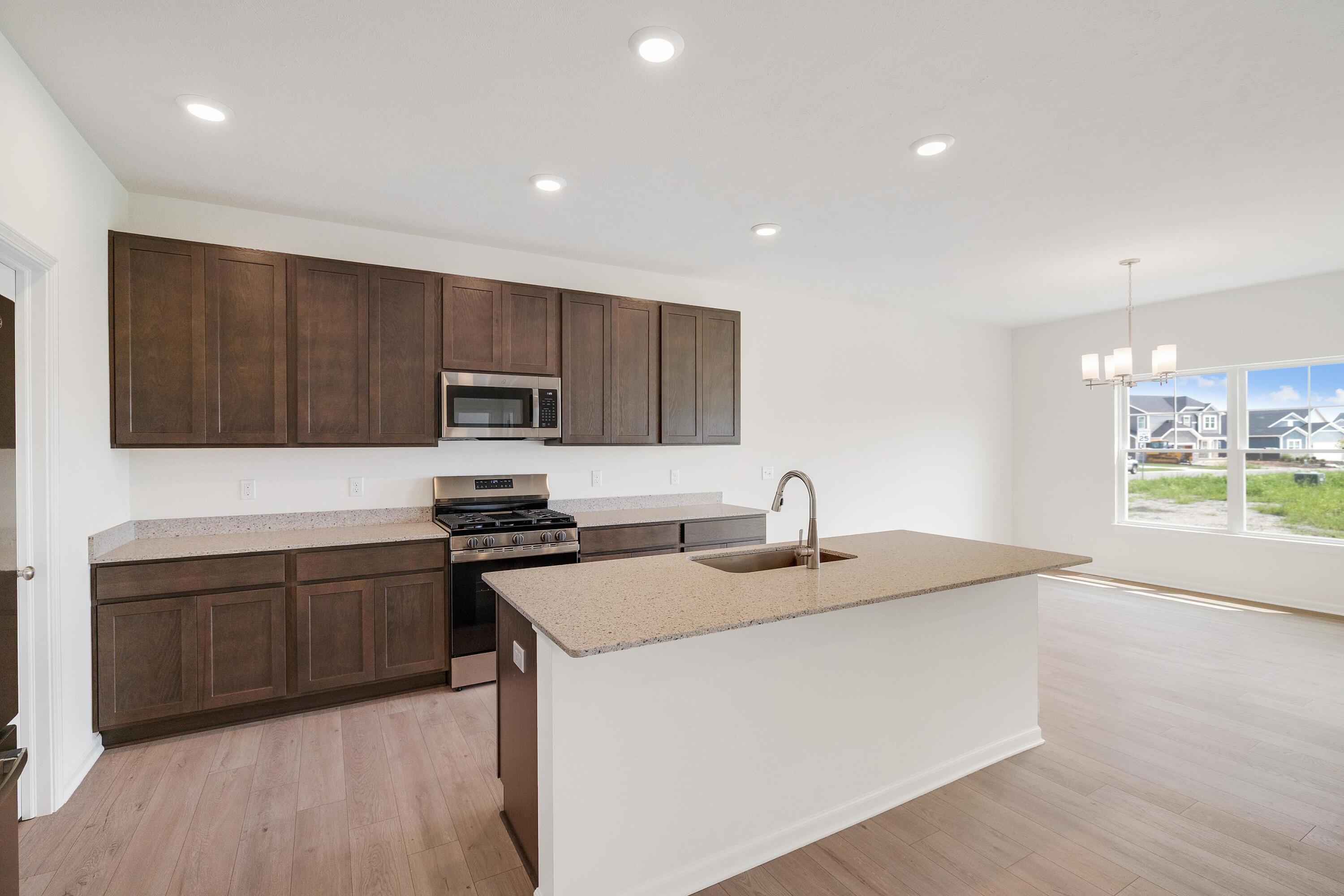 6821 Tucson Road Schererville, IN 46375 - Photo 9 of 24 a kitchen with granite countertop a sink stove and refrigerator