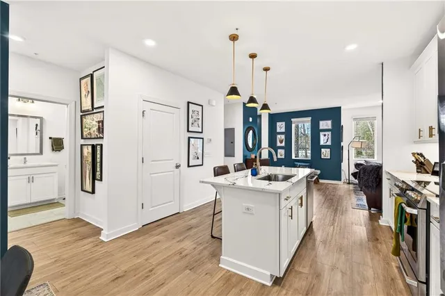 a kitchen with a sink appliances and wooden floor
