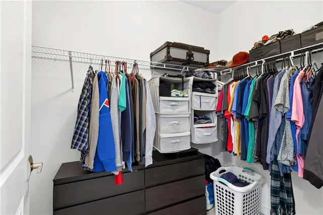 a view of walk in closet with clothes and shoes