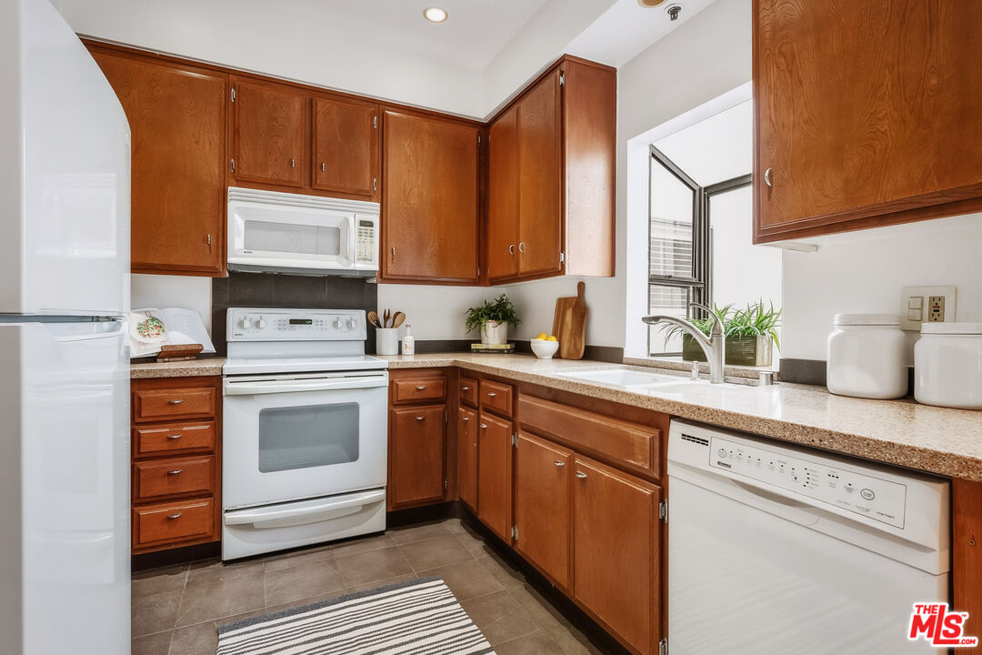 311 Bora Bora Way, Unit 315 Marina del Rey, CA 90292 - Photo 11 of 34 a kitchen with stainless steel appliances a stove a sink and a microwave