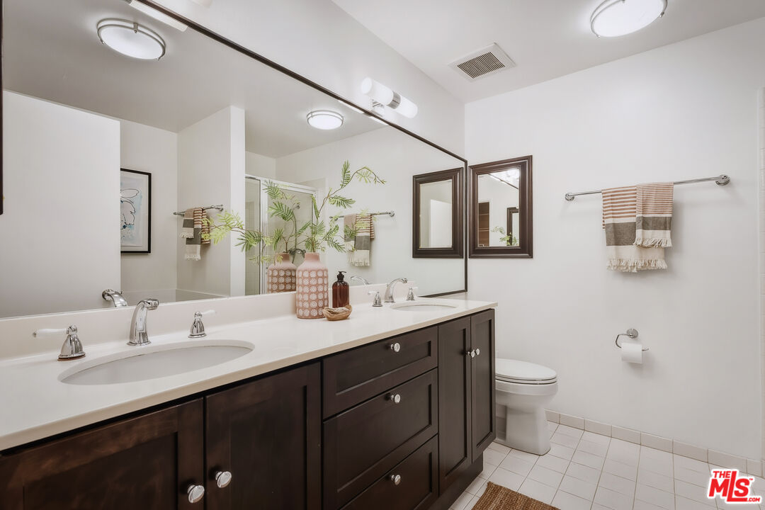 311 Bora Bora Way, Unit 315 Marina del Rey, CA 90292 - Photo 16 of 34 a bathroom with a double vanity sink toilet and mirror