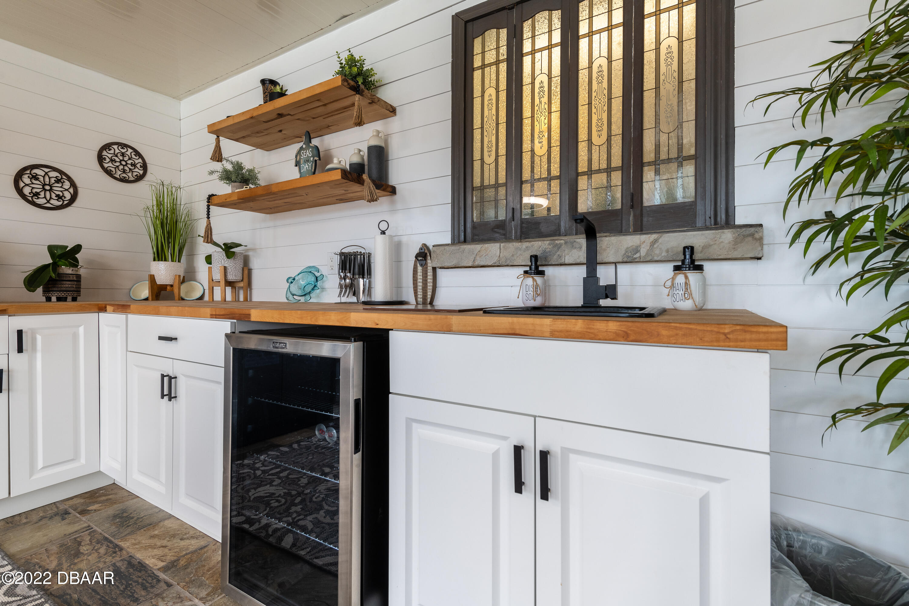 1253 Riverbreeze Boulevard Ormond Beach, FL 32176 - Photo 28 of 39 a kitchen with a sink and a refrigerator