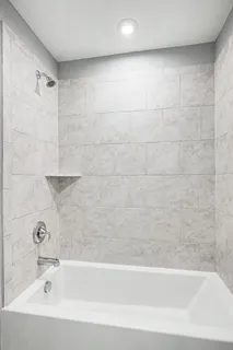 a spacious bathroom with a bathtub sink and mirror