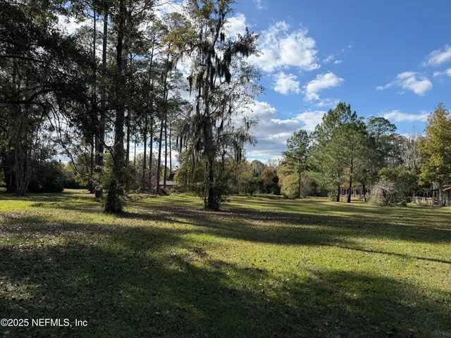 a backyard of a house with lots of green space and fountain