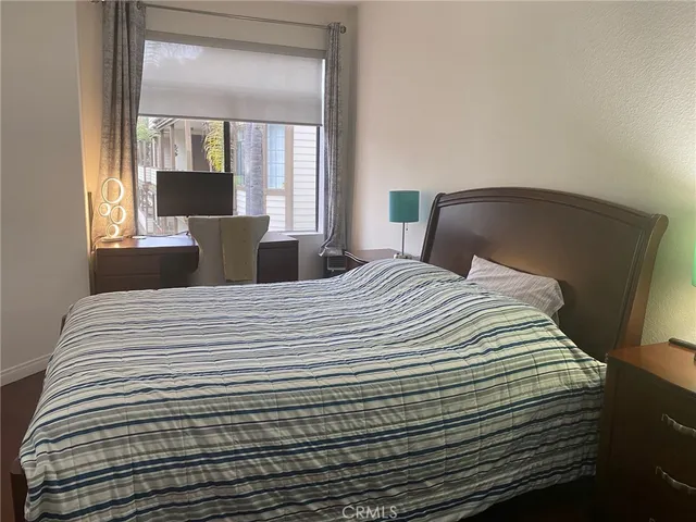 a large white bed in a small room next to a window