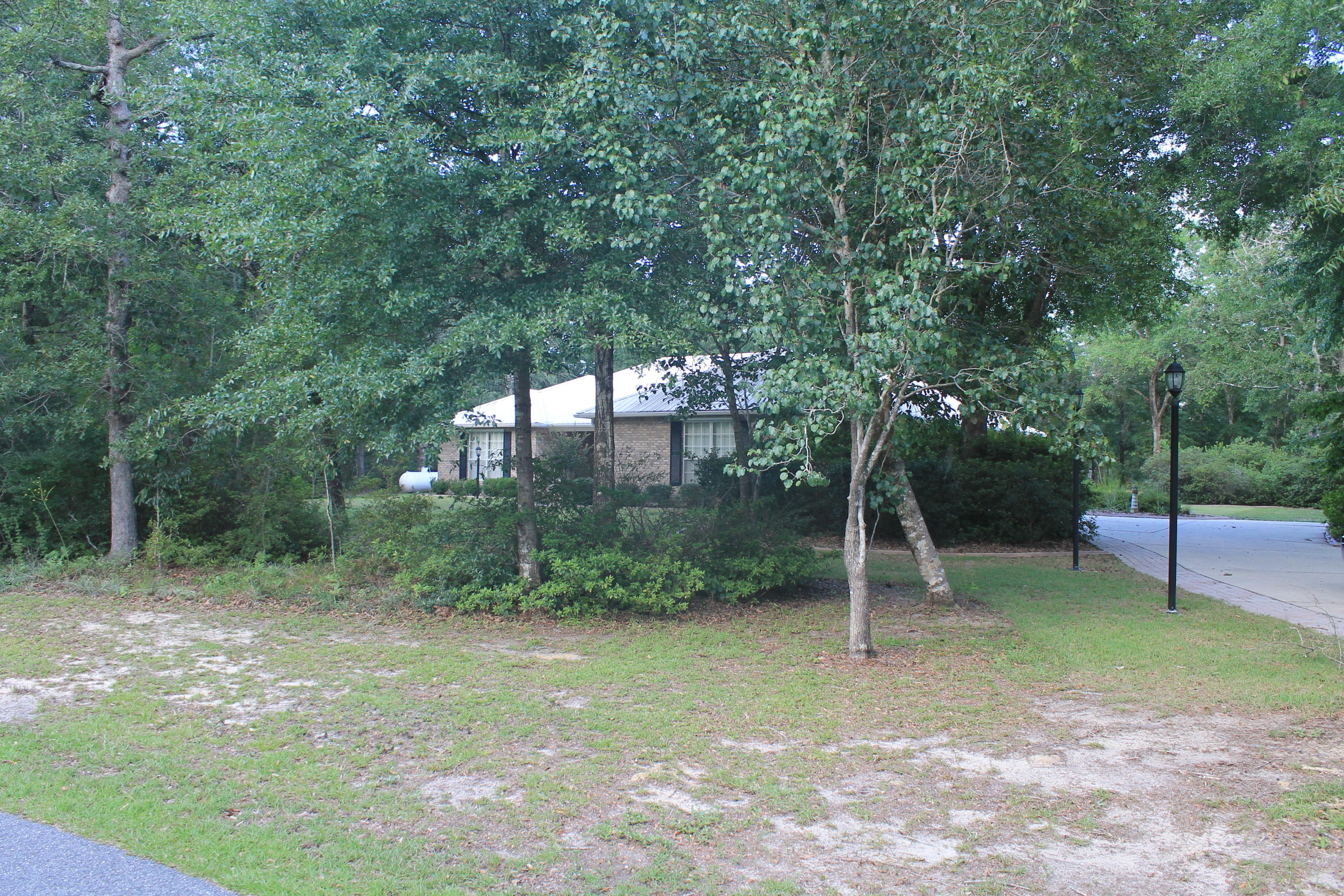 5876 Ward Ranch Road Crestview, FL 32536 - Photo 2 of 50 a backyard of a house with plants and large trees