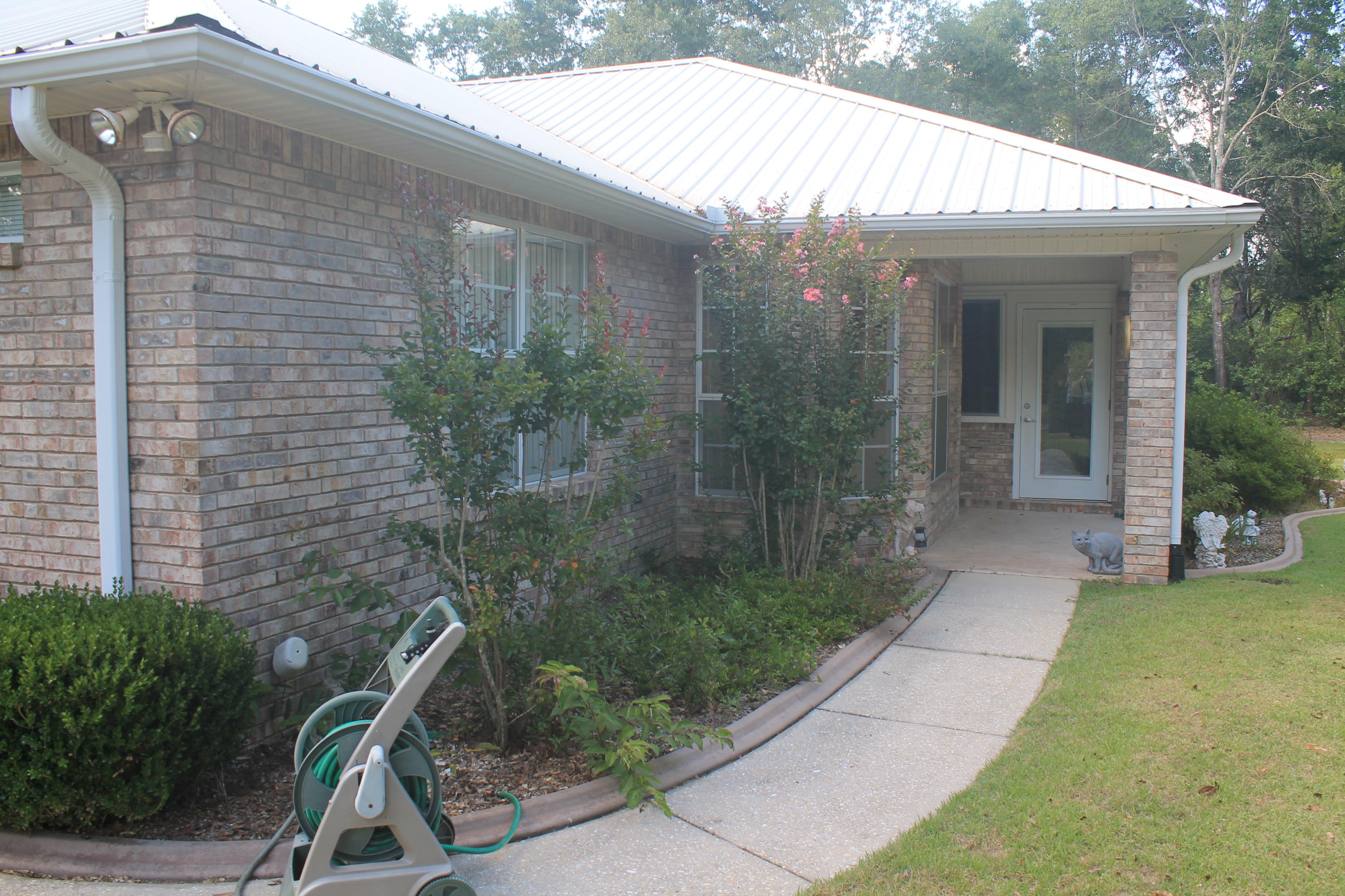 5876 Ward Ranch Road Crestview, FL 32536 - Photo 15 of 50 a view of a porch with a table and chairs under an umbrella