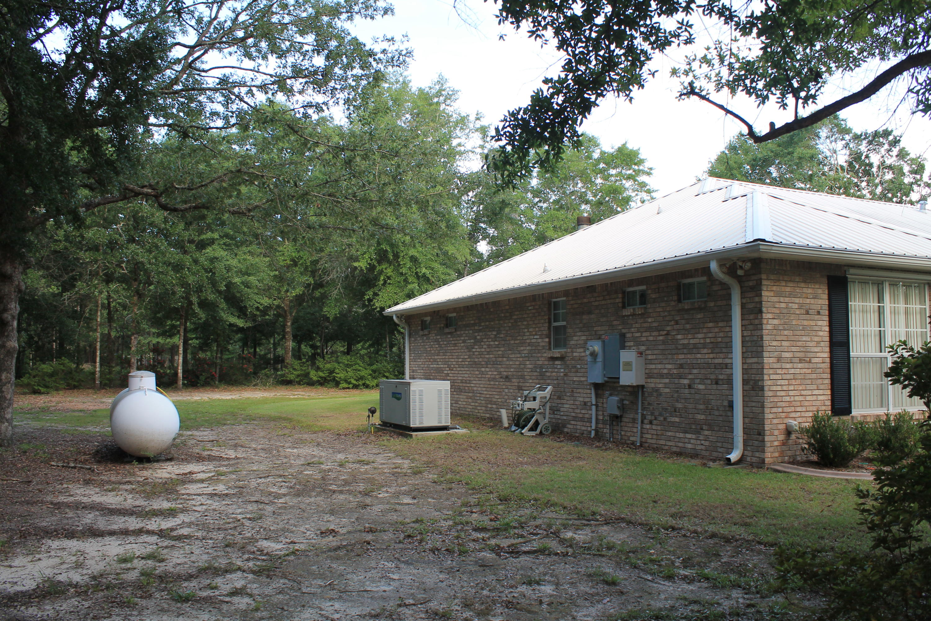 5876 Ward Ranch Road Crestview, FL 32536 - Photo 6 of 50 a view of a backyard with plants and large trees