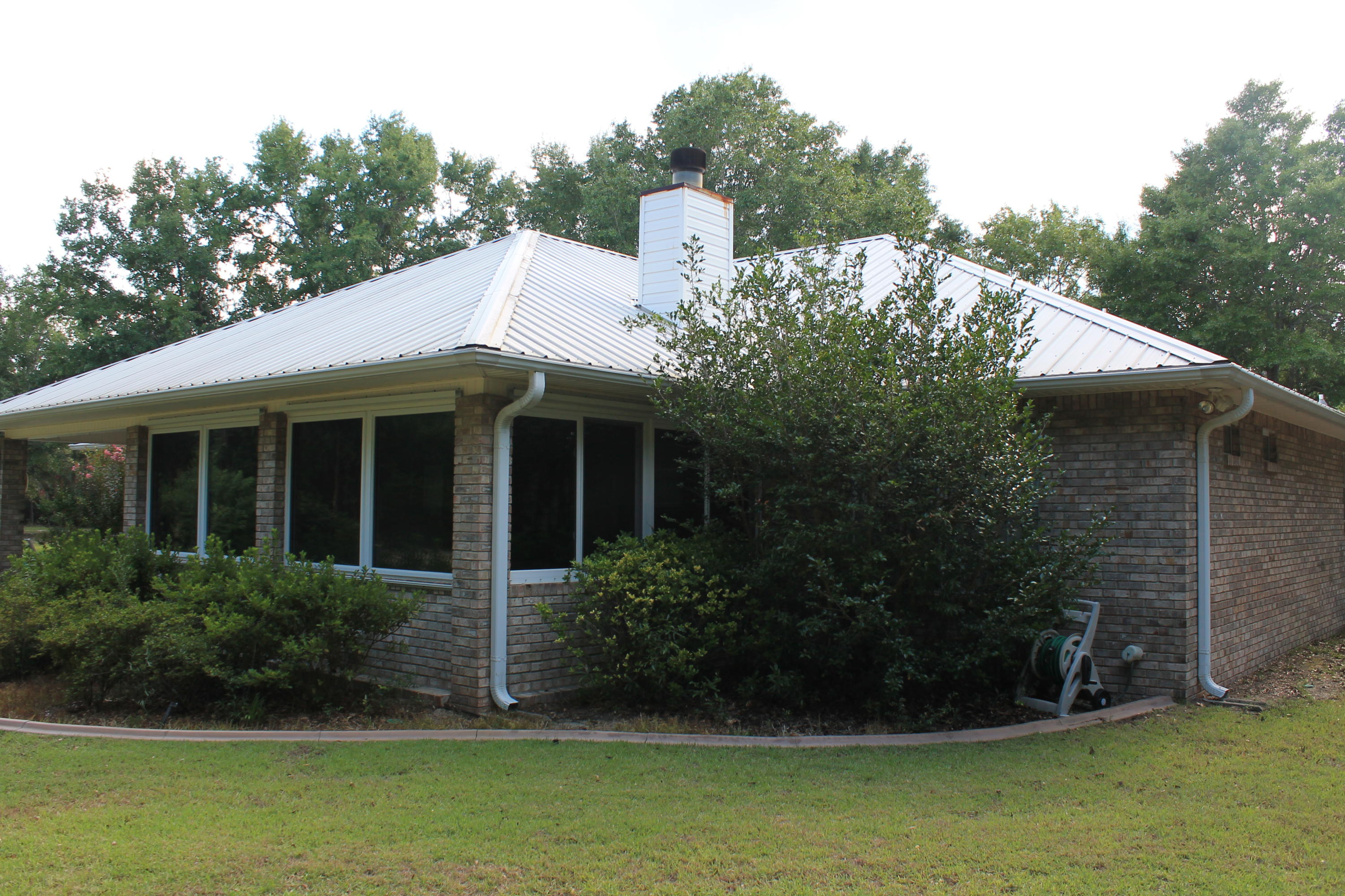 5876 Ward Ranch Road Crestview, FL 32536 - Photo 8 of 50 a view of a white house with a yard potted plants and a table