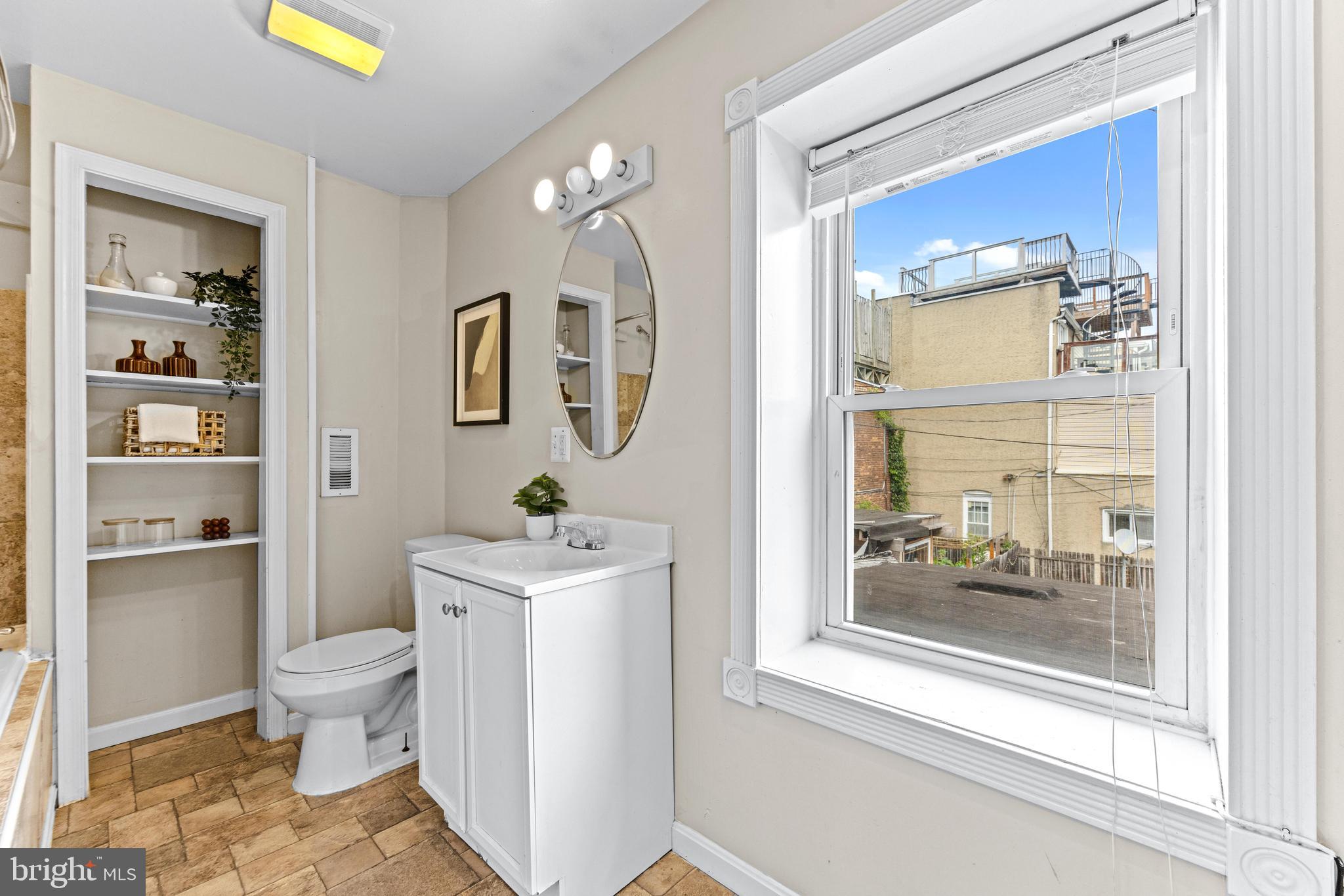 1505 South Hanover Street Baltimore, MD 21230 - Photo 15 of 30 a bathroom with a toilet a sink and a mirror