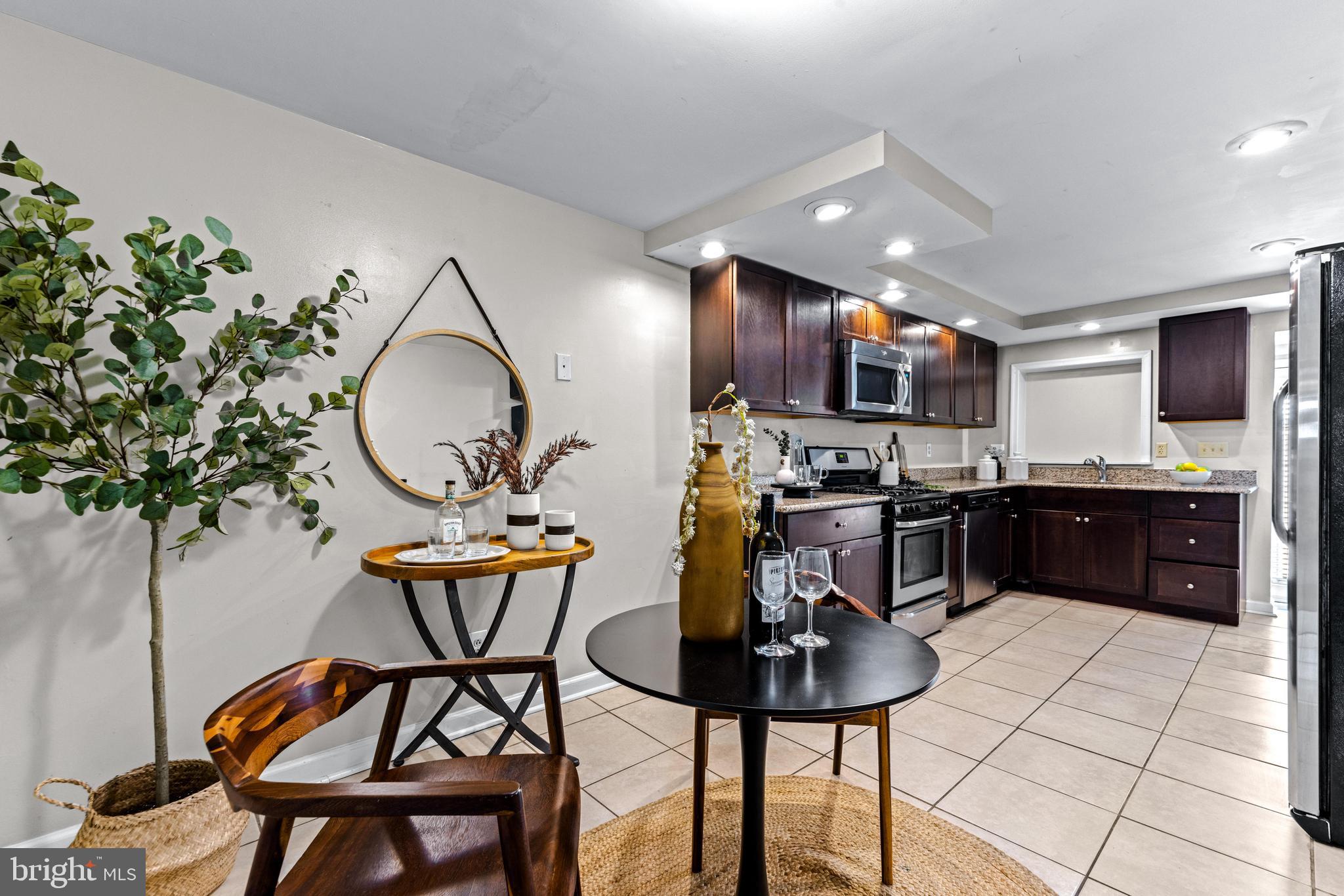 1505 South Hanover Street Baltimore, MD 21230 - Photo 10 of 30 a kitchen with stainless steel appliances a sink a stove a dining table and chairs