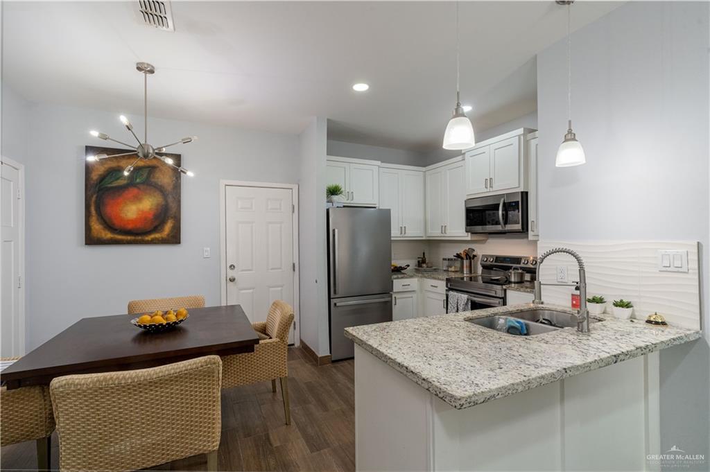 1609 Coyote Edinburg, TX 78541 - Photo 8 of 17 a kitchen with stainless steel appliances granite countertop a sink refrigerator and microwave