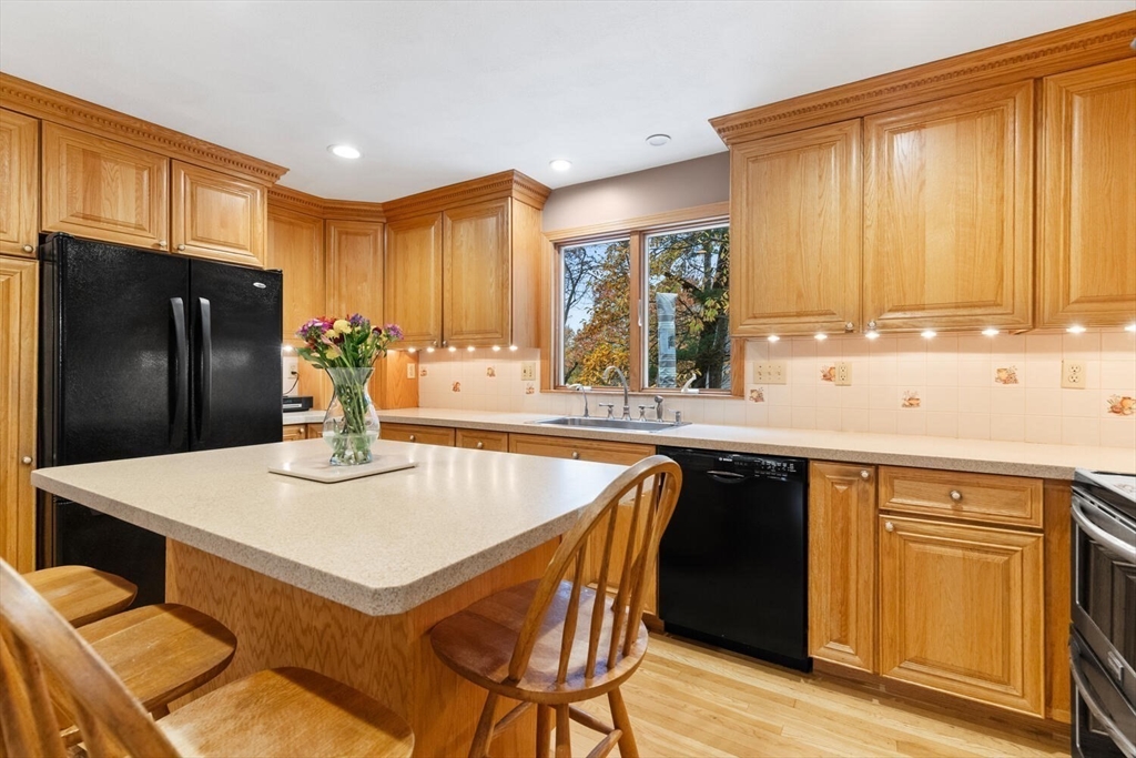 31 Girard Road Winchester, MA 01890 - Photo 15 of 38 a kitchen with stainless steel appliances granite countertop a sink a stove a refrigerator a dining table and chairs