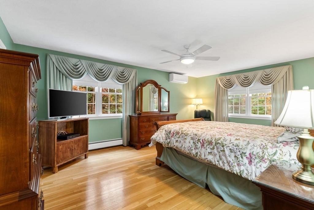 31 Girard Road Winchester, MA 01890 - Photo 22 of 38 a bedroom with a bed and a flat tv screen on dresser
