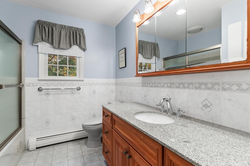 31 Girard Road Winchester, MA 01890 - Photo 30 of 38 a bathroom with a granite countertop sink and a mirror