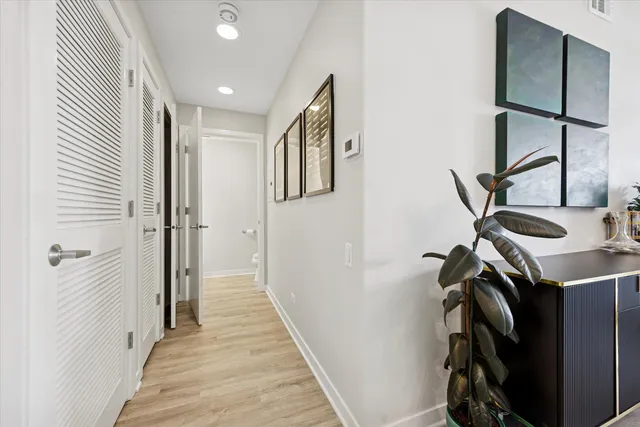 a view of a hallway with wooden floor and staircase