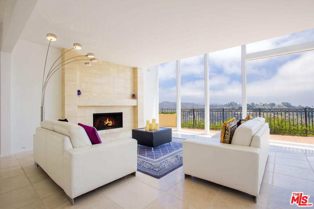 a living room with furniture fireplace and a large window