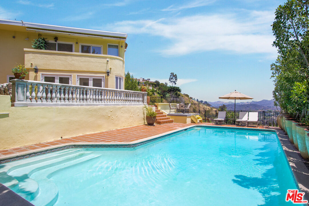 1244 Stradella Road Los Angeles, CA 90077 - Photo 2 of 18 a view of a house with swimming pool and sitting area