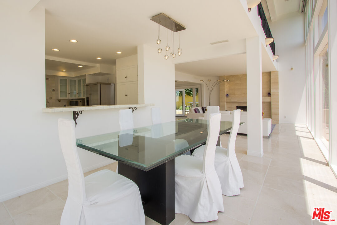 1244 Stradella Road Los Angeles, CA 90077 - Photo 8 of 18 a kitchen with stainless steel appliances kitchen island granite countertop a table and chairs in it