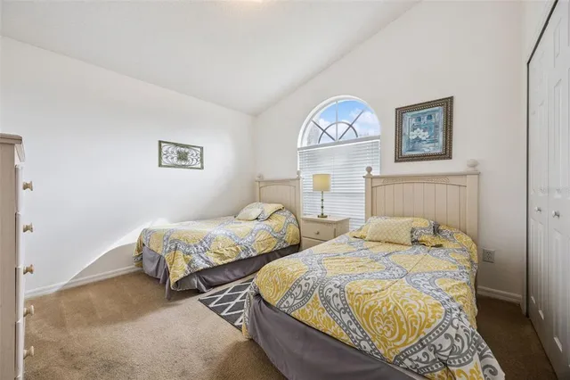 a bedroom with two beds and a lamp on dresser