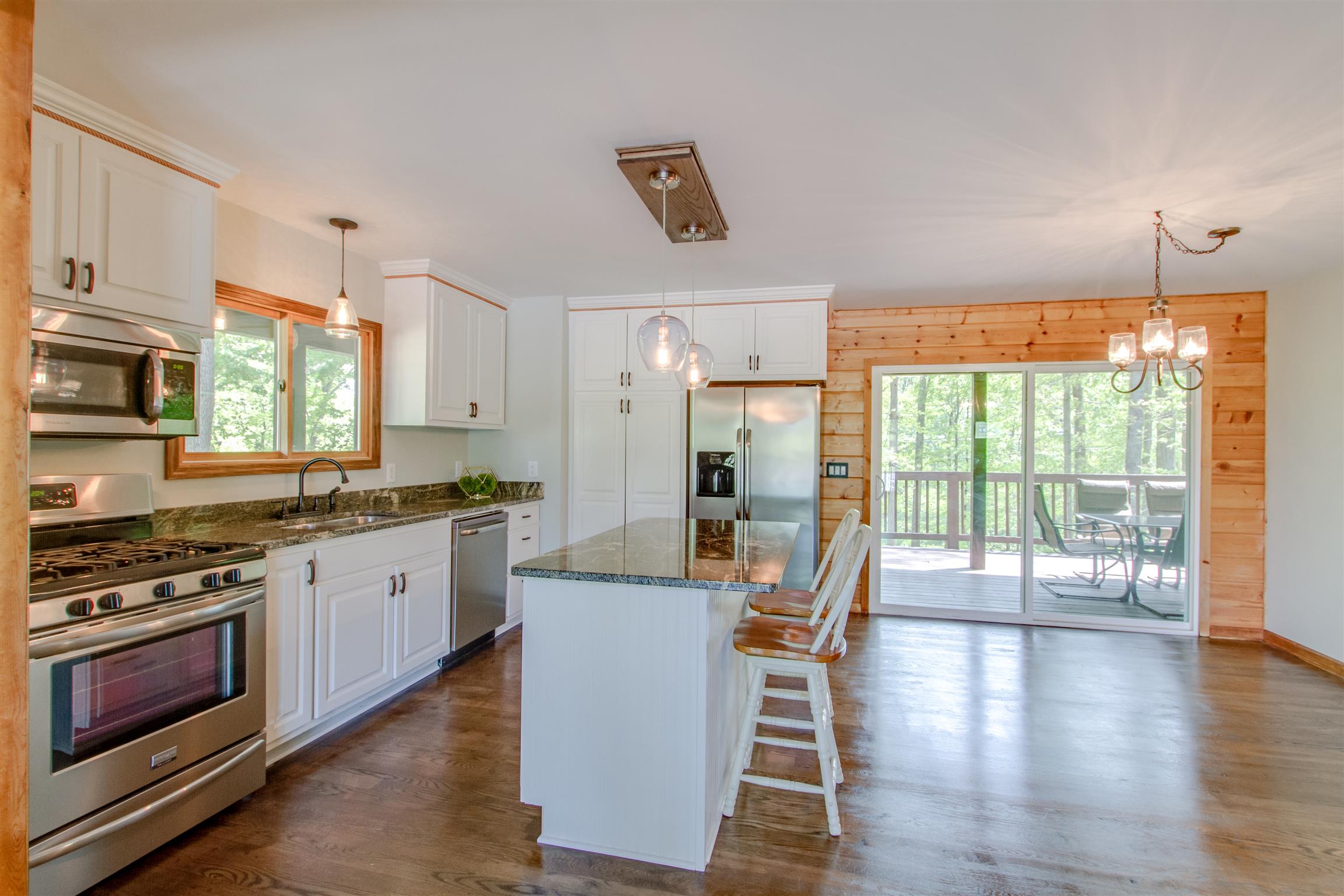 6353 Morton Road Greenbrier, TN 37073 - Photo 14 of 30 a kitchen with stainless steel appliances granite countertop a stove top oven a sink dishwasher a dining table and chairs with wooden floor