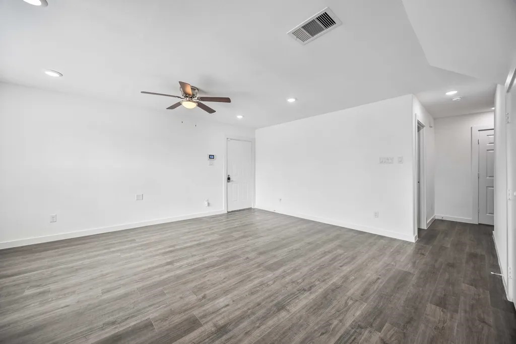 7811 Laura Koppe Road, Unit A Houston, TX 77028 - Photo 11 of 23 an empty room with wooden floor a ceiling fan and windows
