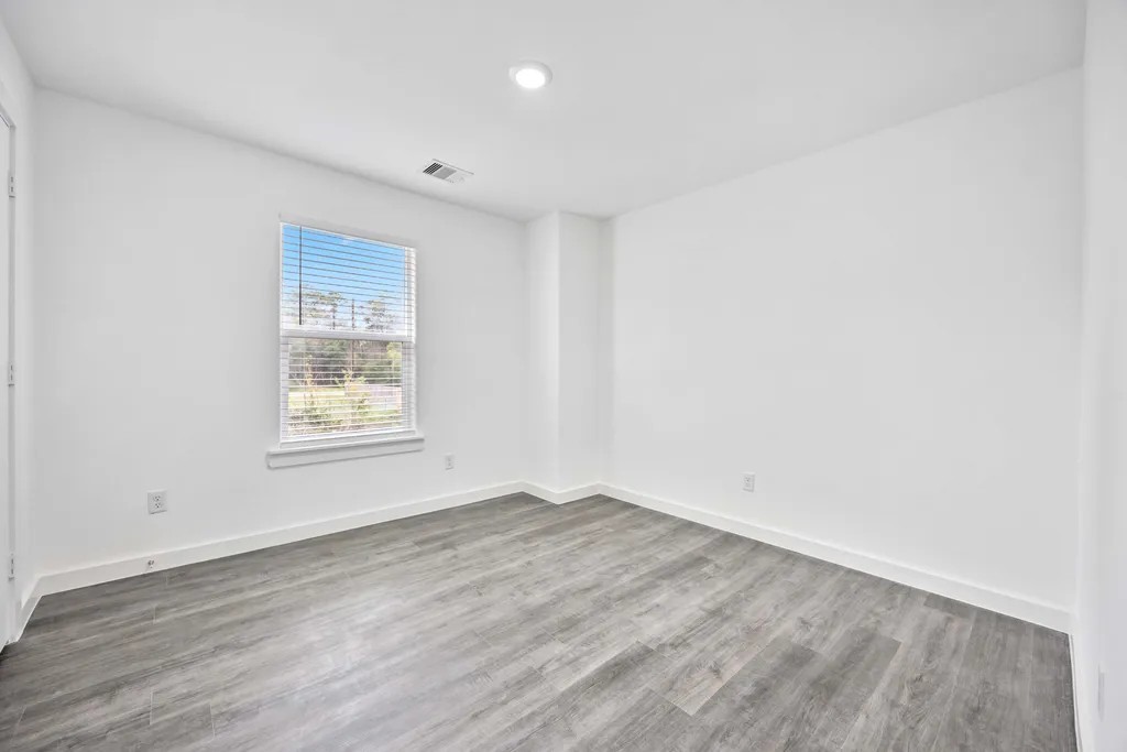 7811 Laura Koppe Road, Unit A Houston, TX 77028 - Photo 17 of 23 an empty room with wooden floor and windows