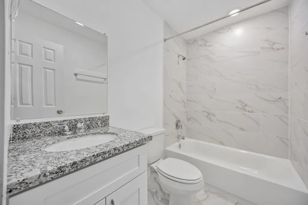 7811 Laura Koppe Road, Unit A Houston, TX 77028 - Photo 18 of 23 a bathroom with a granite countertop sink toilet and shower