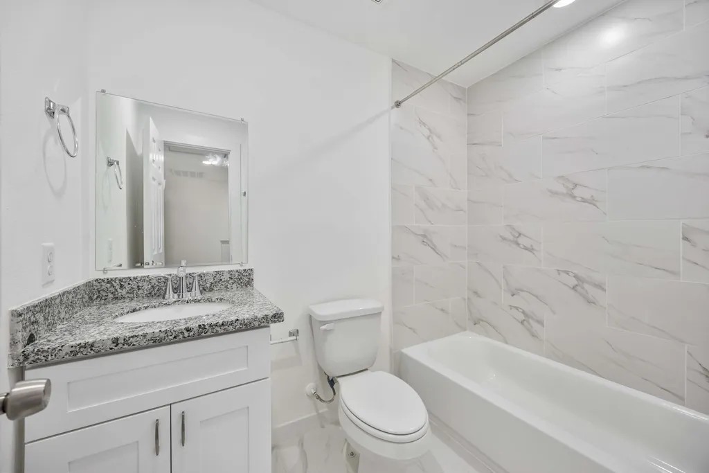 7811 Laura Koppe Road, Unit A Houston, TX 77028 - Photo 6 of 23 a bathroom with a granite countertop sink a toilet and bathtub