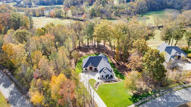 a view of swimming pool with lawn chairs and wooden fence