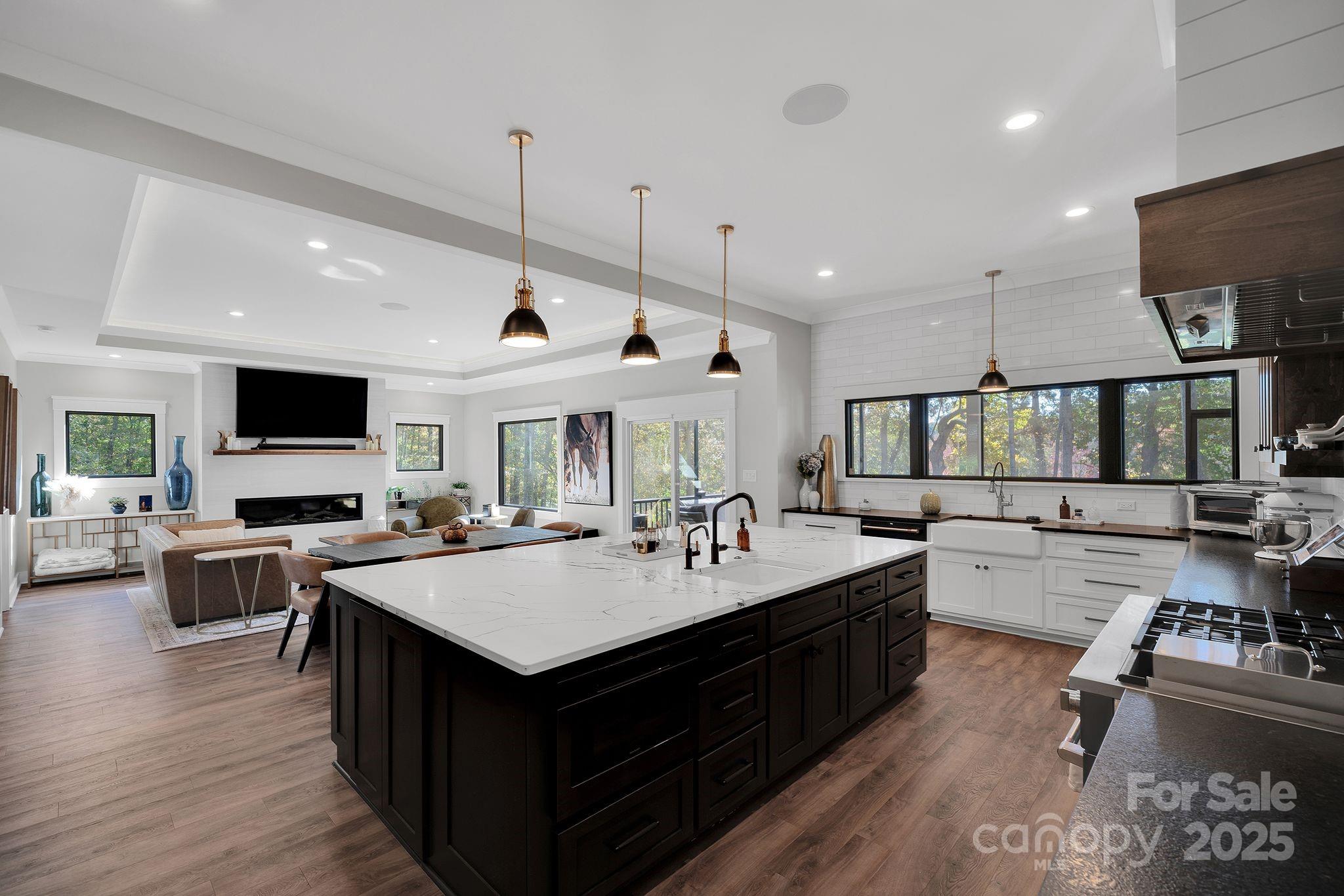 4111 Ridge Drive Northeast Conover, NC 28613 - Photo 14 of 39 a kitchen with a stove a sink dishwasher and a dining table with wooden floor