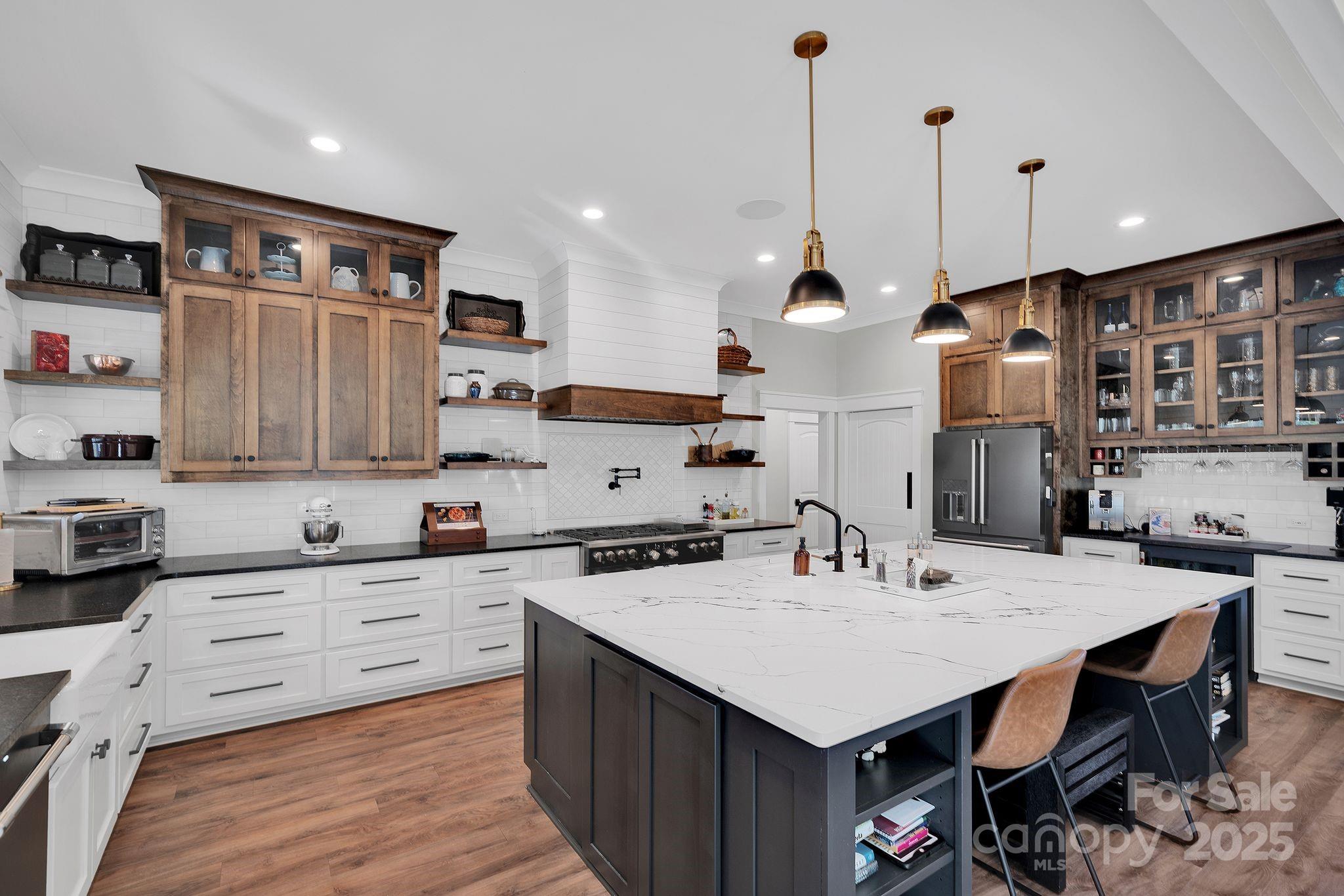 4111 Ridge Drive Northeast Conover, NC 28613 - Photo 15 of 39 a kitchen with a stove a sink a kitchen island with wooden cabinets and chairs