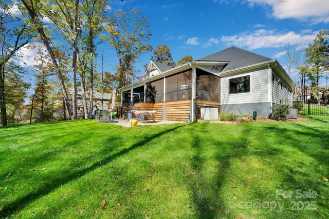 a view of a house with a big yard and large trees
