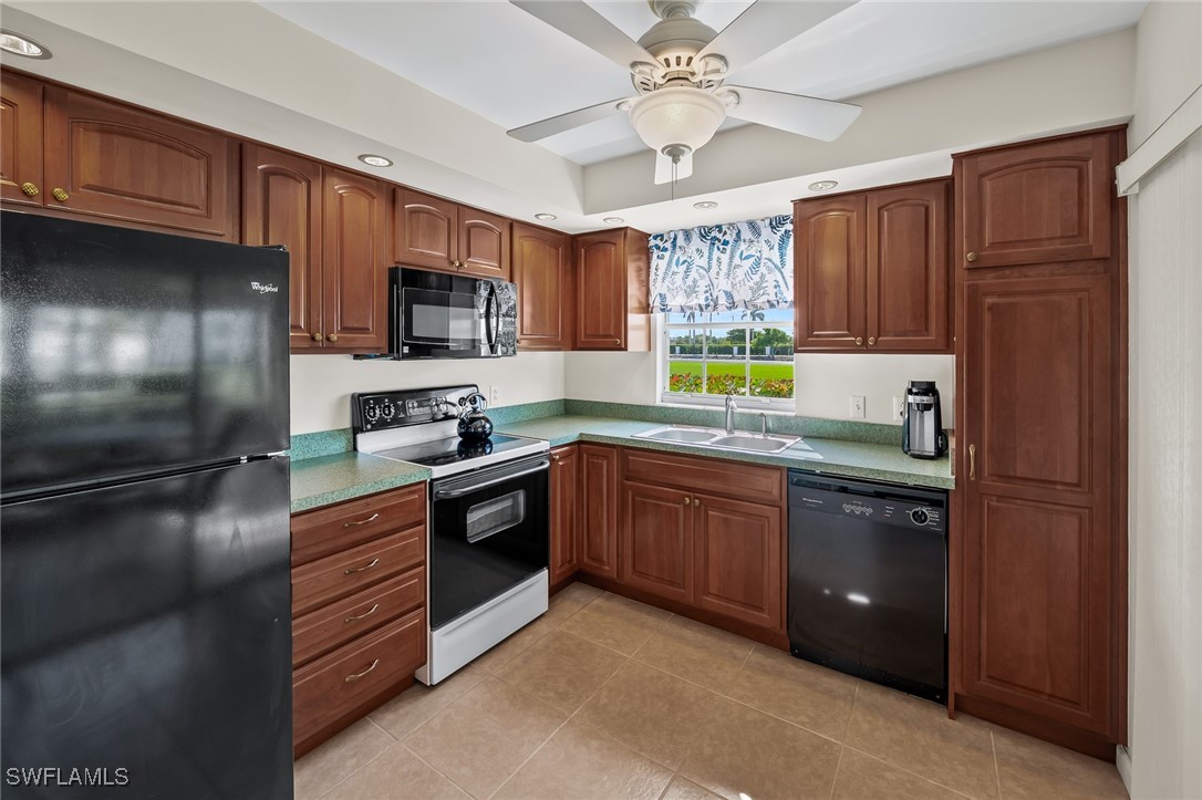 14995 Rivers Edge Court, Unit 151 Fort Myers, FL 33908 - Photo 6 of 18 a kitchen with stainless steel appliances granite countertop a refrigerator a sink dishwasher a stove and a microwave oven