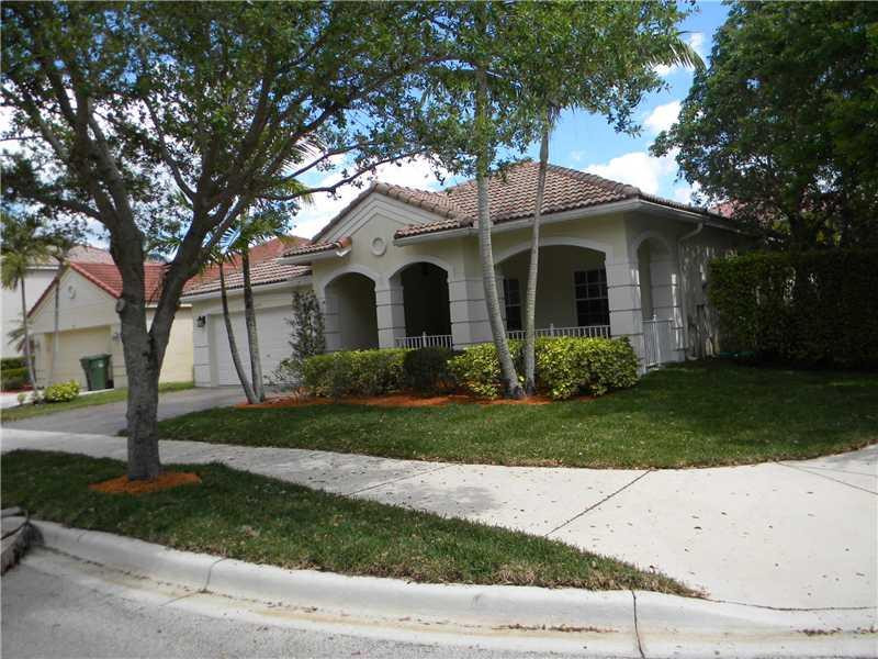 Undisclosed Address Weston, FL 33331 - Photo 3 of 23 a front view of a house with a yard and a garage