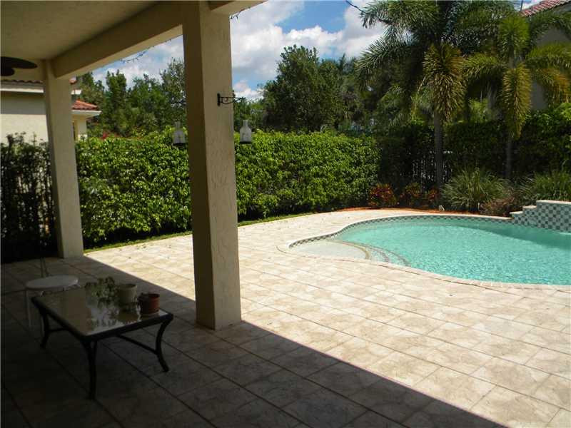 Undisclosed Address Weston, FL 33331 - Photo 6 of 23 a view of a swimming pool with lawn chairs under an umbrella