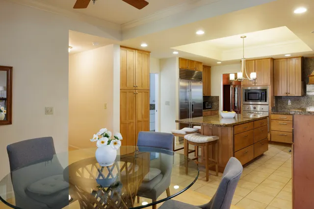 a kitchen with a dining table chairs stainless steel appliances and cabinets
