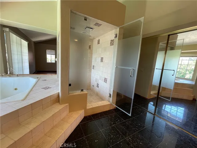 a spacious bathroom with a double vanity sink a large mirror and a shower