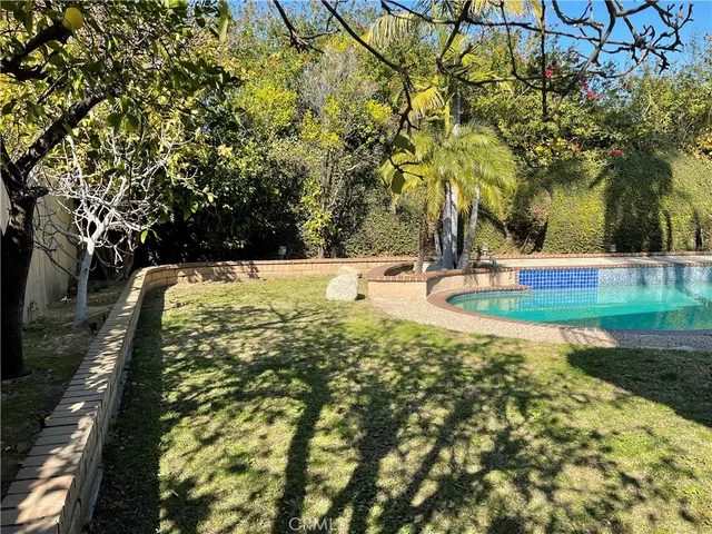 a front view of a house with garden and trees