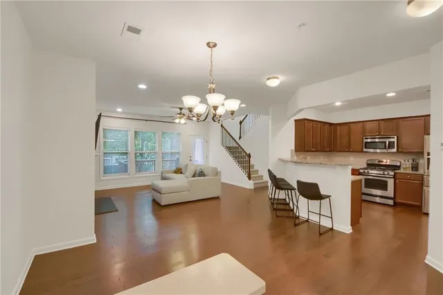 a view of a dining room and livingroom with furniture wooden floor a chandelier