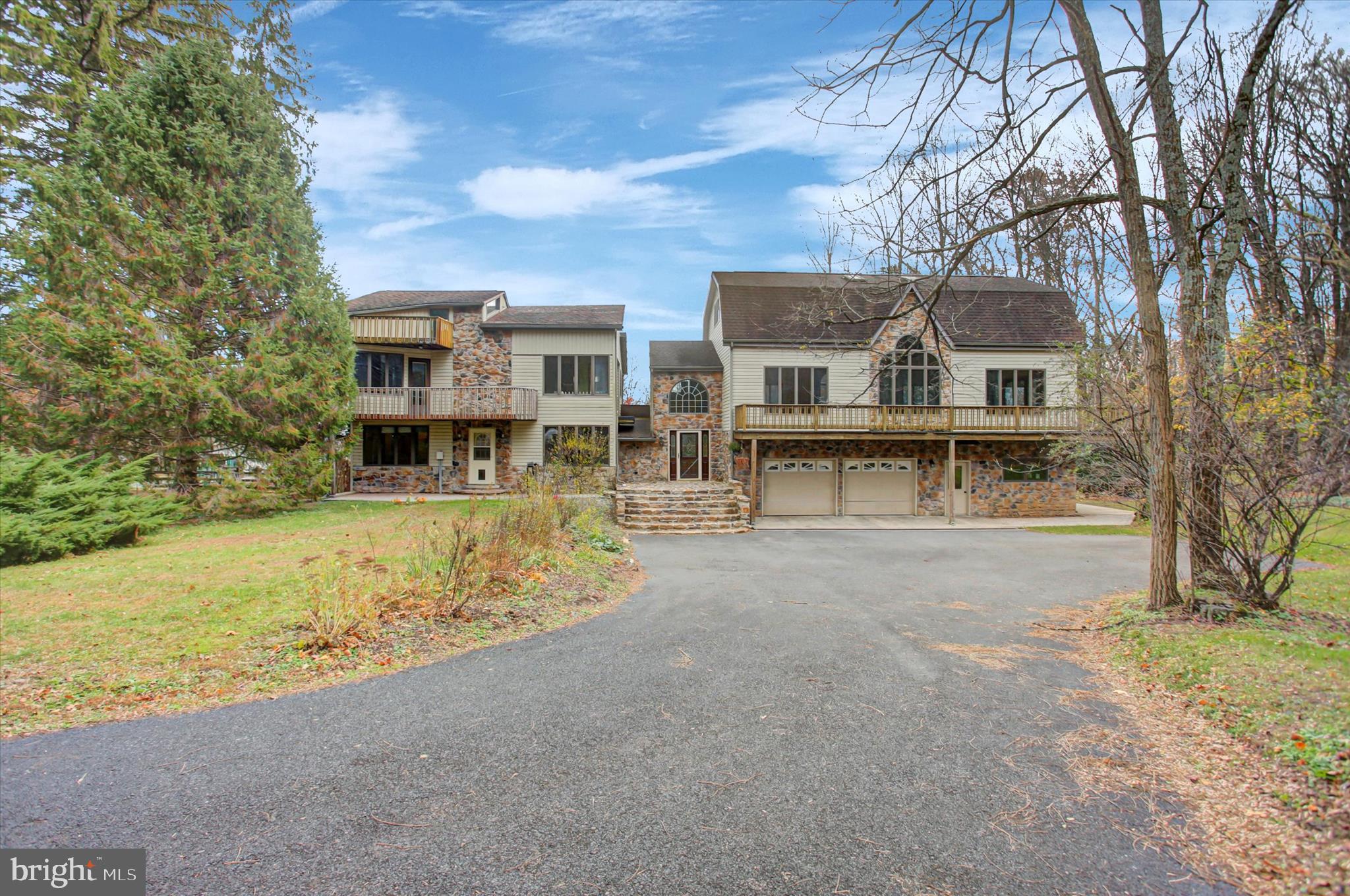 a view of a house with a yard and large tree