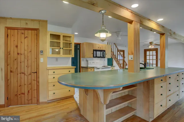 a view of an empty room with wooden floor and a fireplace