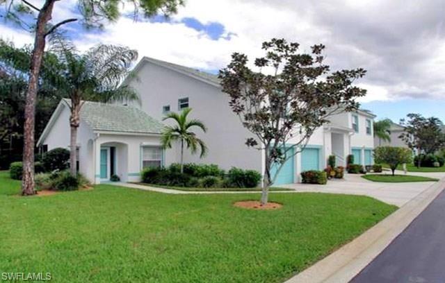 960 Partridge Circle, Unit 1202 Naples, FL 34104 - Photo 15 of 23 a front view of a house with garden and trees