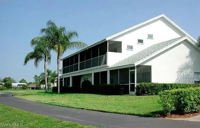 a view of house with yard and tree in front of it