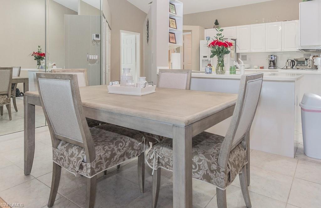 960 Partridge Circle, Unit 1202 Naples, FL 34104 - Photo 4 of 23 a dining table with chairs and flower