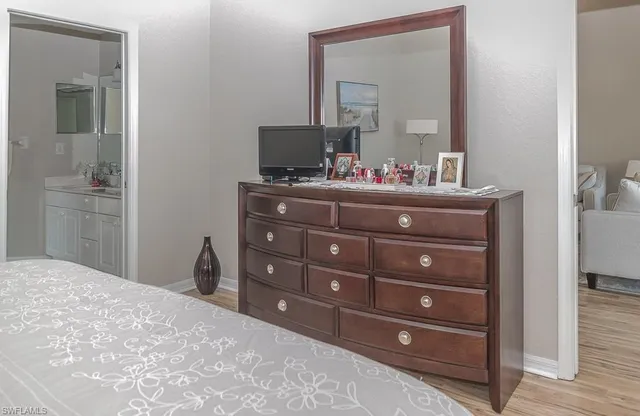 a bedroom with a bed and a mirror on dresser