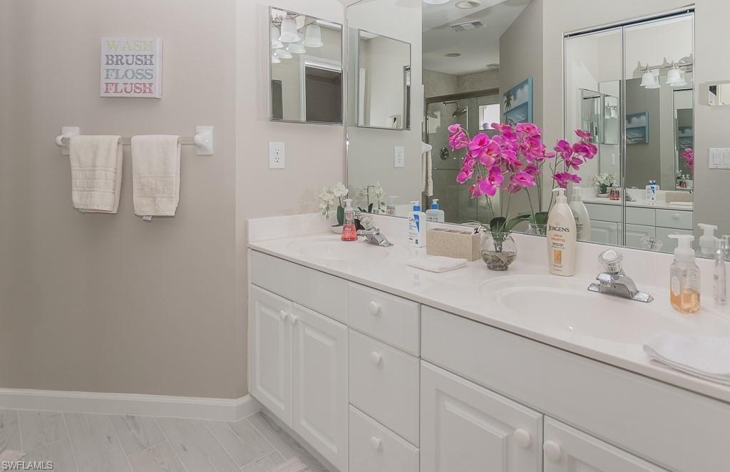 960 Partridge Circle, Unit 1202 Naples, FL 34104 - Photo 8 of 23 a bathroom with a sink vanity and mirror